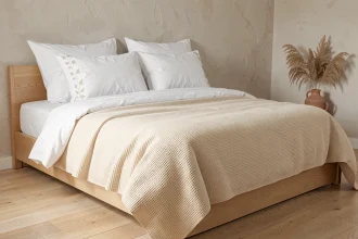 Chambre épurée au style scandinave avec un lit fait de draps en lin blanc et une housse de couette en coton gaufrée ivoire, décoration minimaliste et chaleureuse