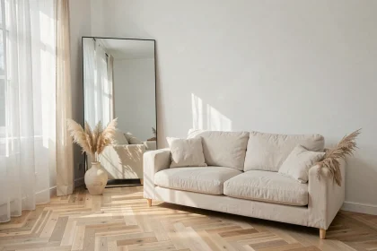 Grand miroir rectangulaire appuyé contre un mur blanc dans un salon scandinave pour agrandir visuellement l'espace